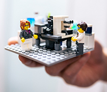 Forschungslabor aus Lego, in dem zwei Wissenschaftler an Mikroskopen arbeiten